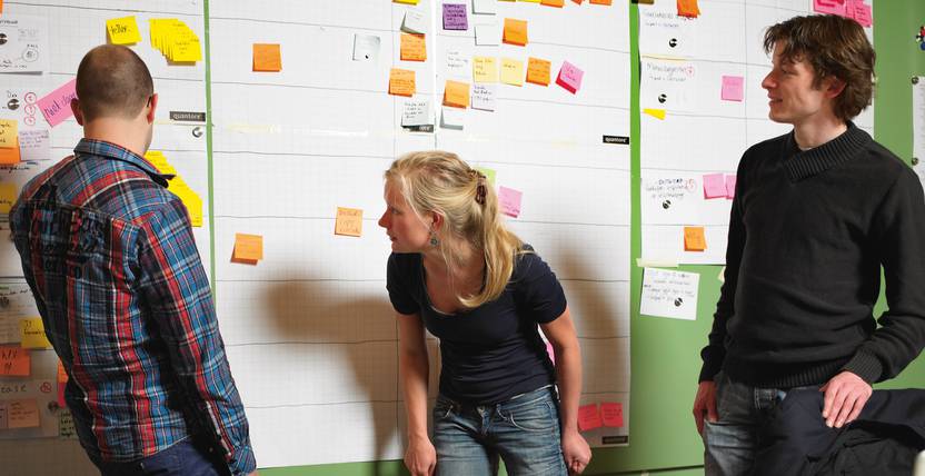 Teamleden in actie bij het scrumboard. Bij Fabrique hebben we jarenlange ervaring met Scrum.