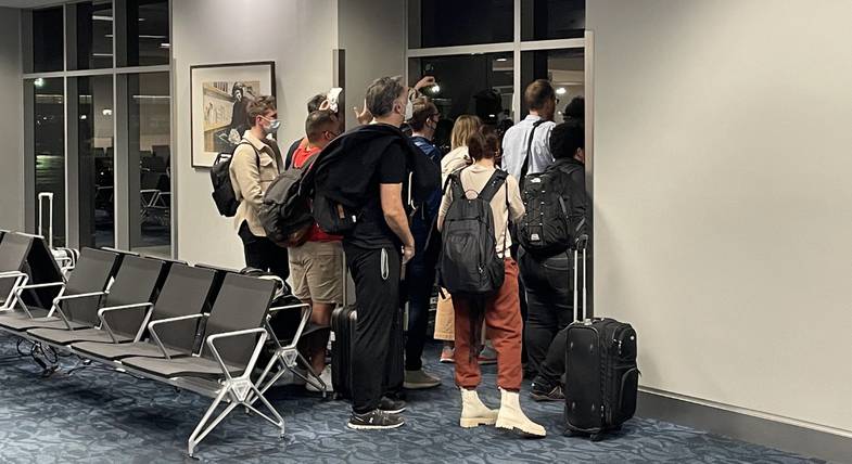 Mensen kijken door het raam naar een vertrekkend vliegtuig op het vliegveld