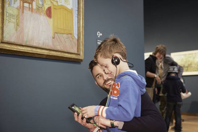 Vader en zoon doen de Van Gogh Museum tour in the museum